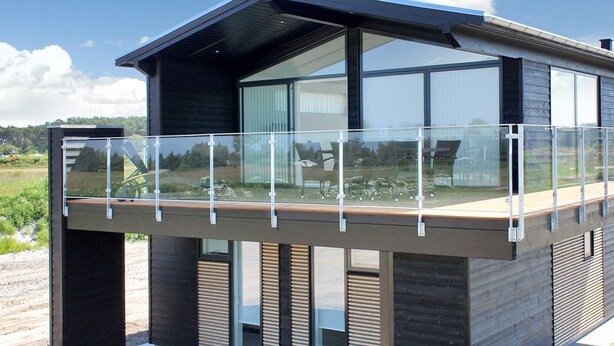 Un bâtiment moderne doté d’un balcon et de grandes fenêtres.