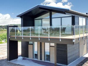 Een modern gebouw met een balkon en grote ramen.
