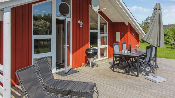 A red building with a deck, outdoor seating, and a grill. - "Menka" - 1.3km from the sea by Interhome (Bindslev)