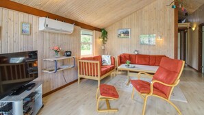 A cozy cabin interior with a wooden ceiling, a sofa, two chairs, a TV, and a small table. - "Menka" - 1.3km from the sea by Interhome (Bindslev)