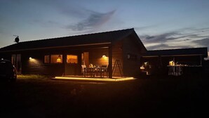 A wooden cabin with a porch, a dining area, and a visible garage. - "Hinda" - 1.2km from the sea by Interhome (Bindslev)