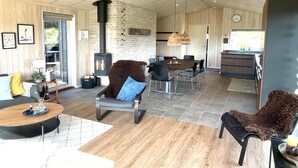 A spacious living area with a fireplace, dining table, and modern furniture. - "Hinda" - 1.2km from the sea by Interhome (Bindslev)
