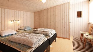 A bedroom with a bed, a nightstand, a wall-mounted lamp, and a window.