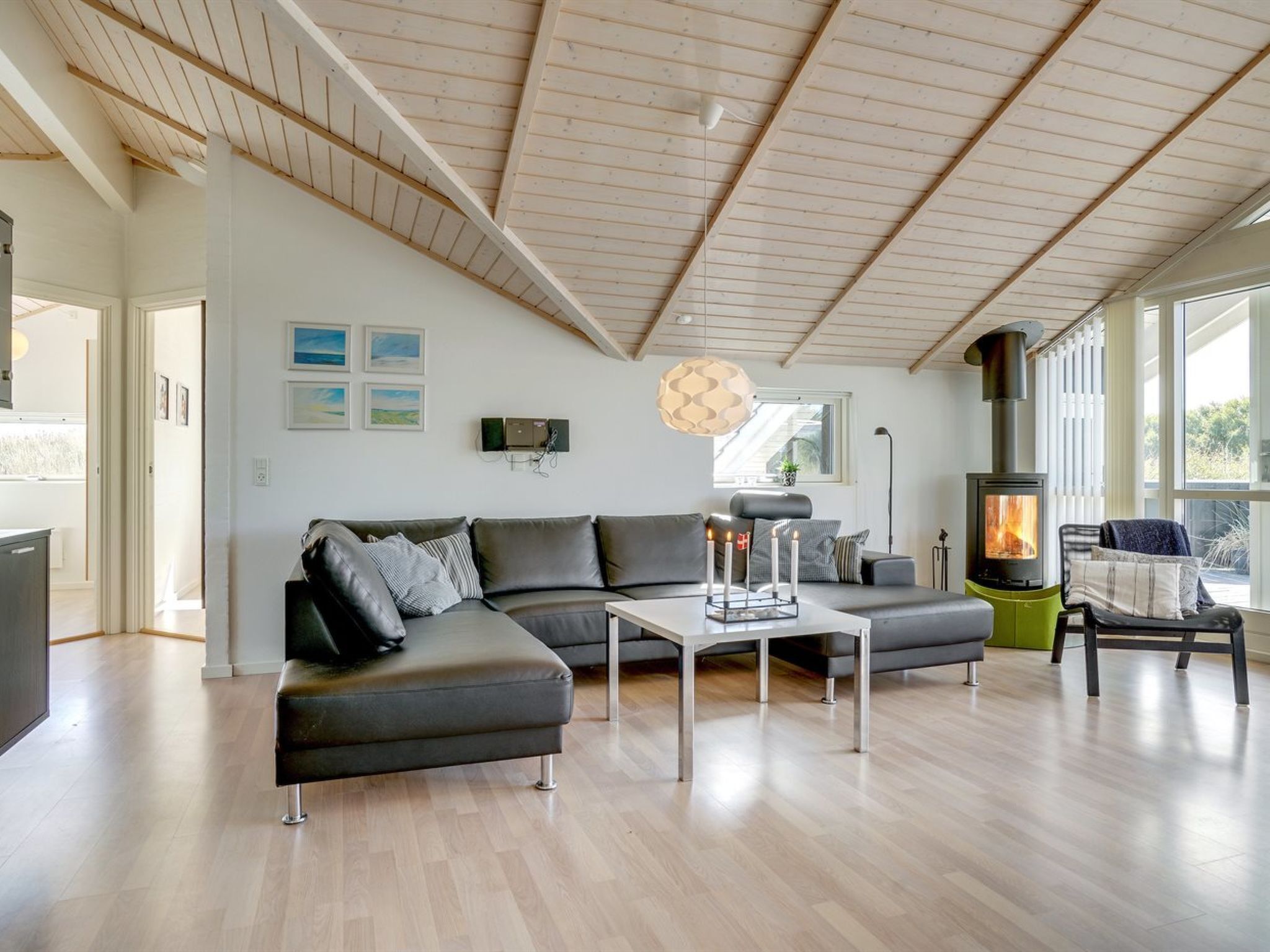 Un salon moderne avec un canapé d’angle, une table basse et un poêle à bois.