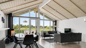 Een modern interieur met een eethoek, een bank en een televisie.