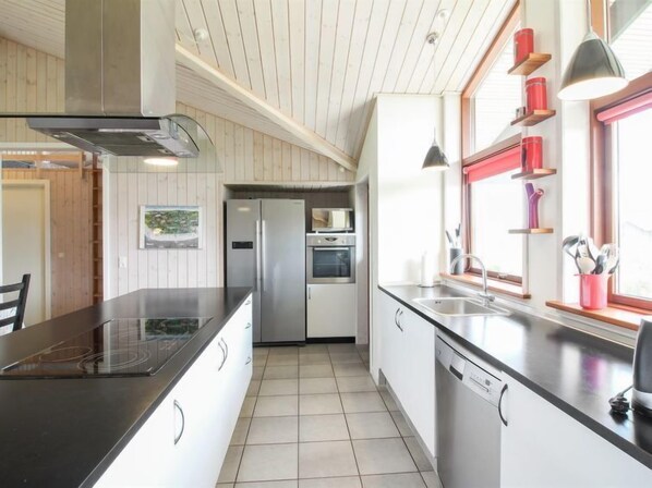 Enjoy cooking in this well-equipped kitchen with a central island, stovetop, and modern appliances.