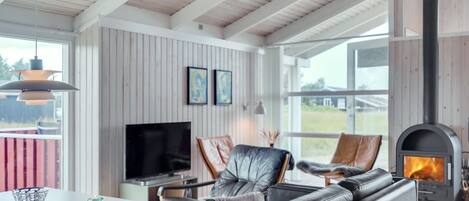 A modern living room with a fireplace, leather sofa, and a TV.