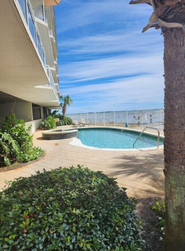 Relax by the pool surrounded by lush greenery and take in the views from the adjacent building's balcony.