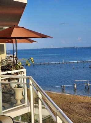 Enjoy breathtaking sea views from this balcony, complete with a charming umbrella and lush greenery.