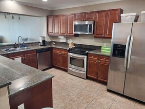 Enjoy cooking in this well-equipped kitchen with a stainless steel refrigerator, double oven, and microwave.
