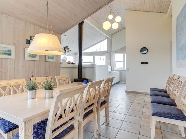 A modern kitchen with wooden cabinets, a large island, and pendant lighting.