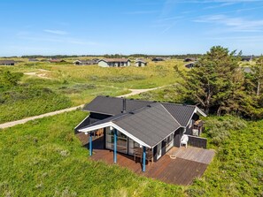 A modern house with a large deck, surrounded by a grassy landscape and other houses. - "Wilma" - 400m from the sea by Interhome (Hirtshals)