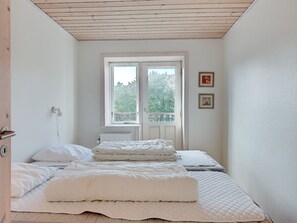 Ein Schlafzimmer mit Bett, Fenster und Heizkörper.