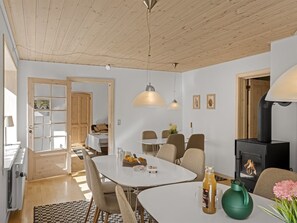 Un interior moderno con comedor, cocina y chimenea.