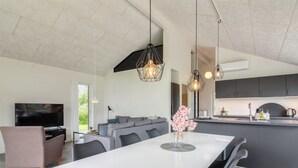 A modern kitchen with dark cabinets, a central island, and pendant lighting.
