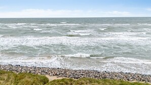 Una costa rocciosa con onde che si infrangono sulla spiaggia.