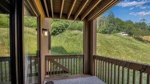 A wooden deck with a view of a grassy landscape.