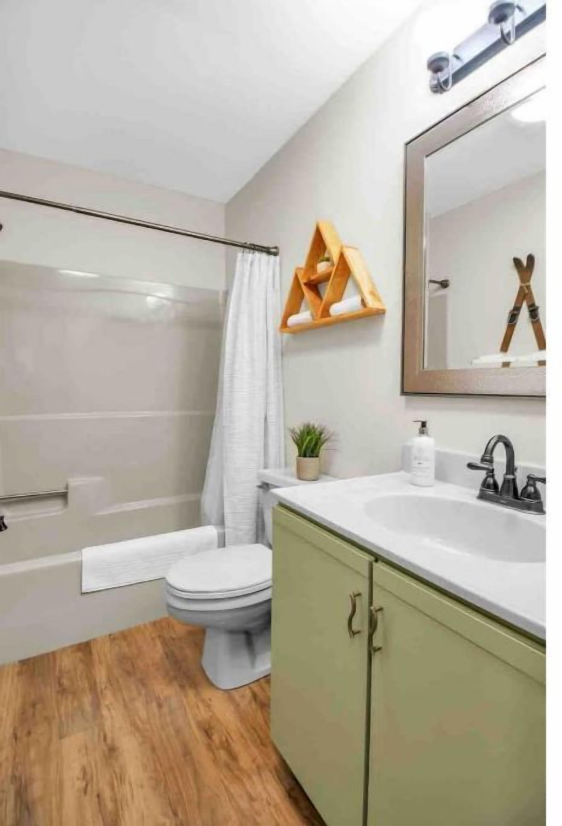 Une salle de bain avec douche, toilettes et lavabo.