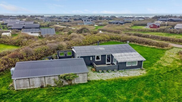 Un quartiere residenziale con diverse case, ciascuna dotata di tetto piano e circondata da prati verdi.