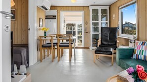 A compact living space with a dining area, a sofa, and a window with a view.