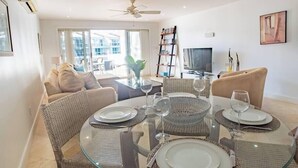 En matplats med ett glasbord, flätade stolar och en soffa i bakgrunden.