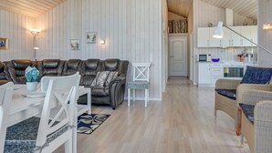 Un intérieur moderne comprenant un espace de vie, un coin repas et une cuisine.