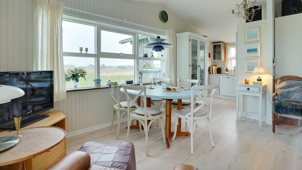 A spacious living room with a dining area, a television, and a view of the outdoors. - "Stavros" - 410m from the sea by Interhome (Hjørring)