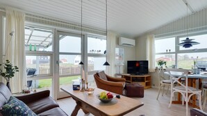 A spacious living room with a sofa, a wooden coffee table, and a television. - "Stavros" - 410m from the sea by Interhome (Hjørring)