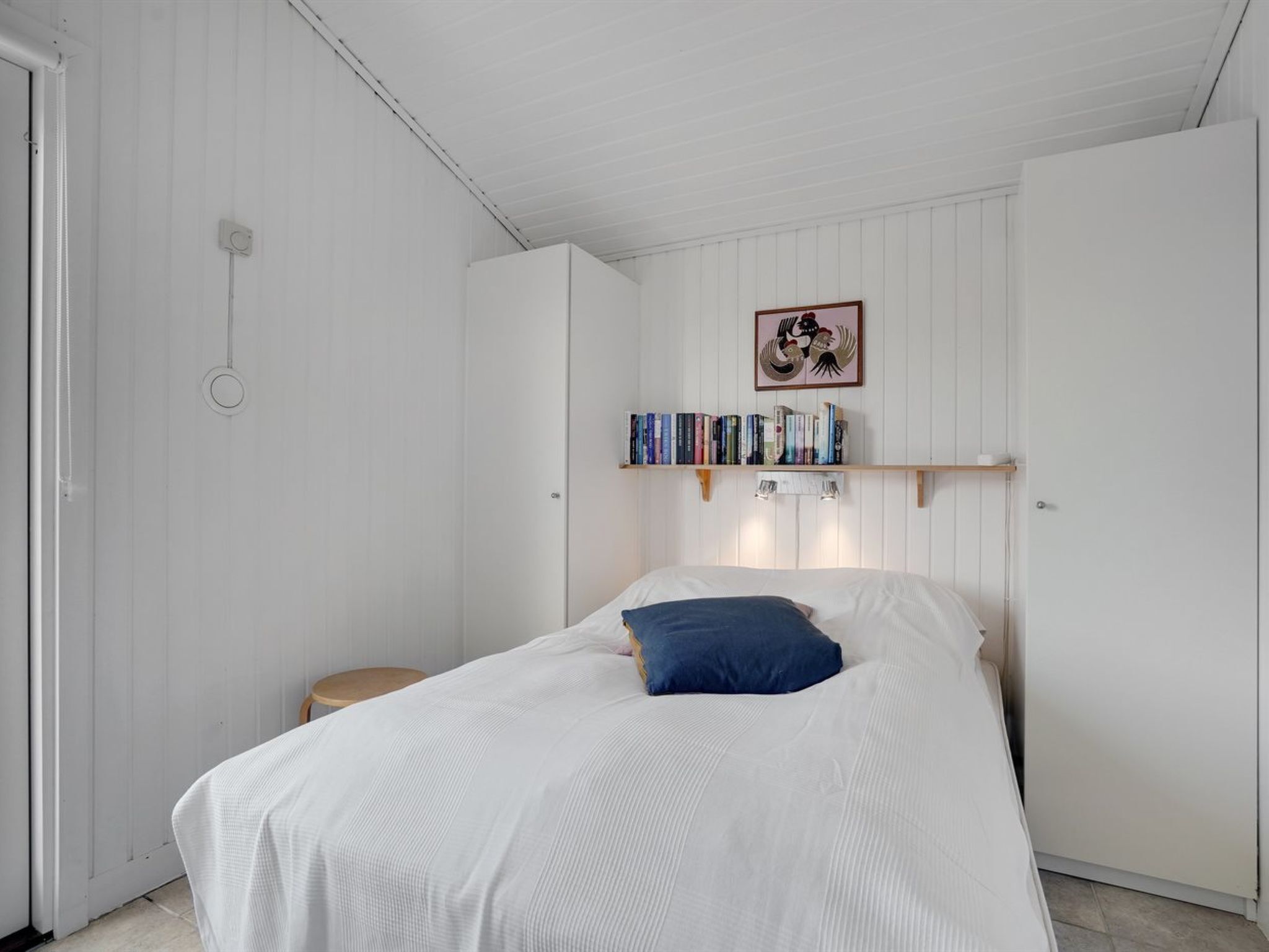 Una camera da letto con un letto, una libreria e una porta.