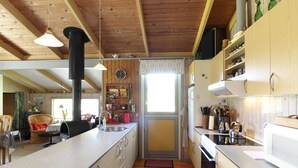 Una cocina compacta con armarios de madera, una isla central y un comedor con sillas y una mesa.