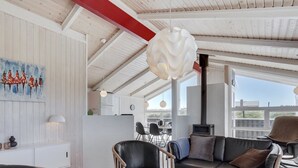 A modern interior with a dining area, a sofa, and a table with a menu.