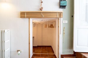 A hallway with a radiator, a wooden door frame, and a tiled floor.
