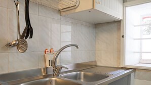 A kitchen with two stainless steel sinks, a modern faucet, and a window with a view. - GuestHost - Lovely apartment that hosts up to 2 people, located in an old farmhouse dating back to the 19th century, furnished with taste and meticulous recovery of the original materials. The accommodation is located in Cozzana, a quiet and verdant dist (Monopoli)