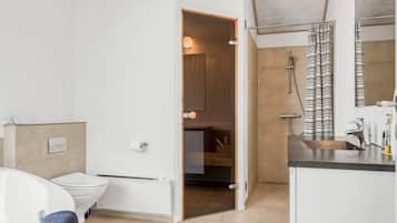 Une salle de bain moderne équipée d’une baignoire, de toilettes et d’un espace douche.