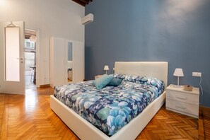 Een slaapkamer met een bed, nachtkastjes en een kledingkast.