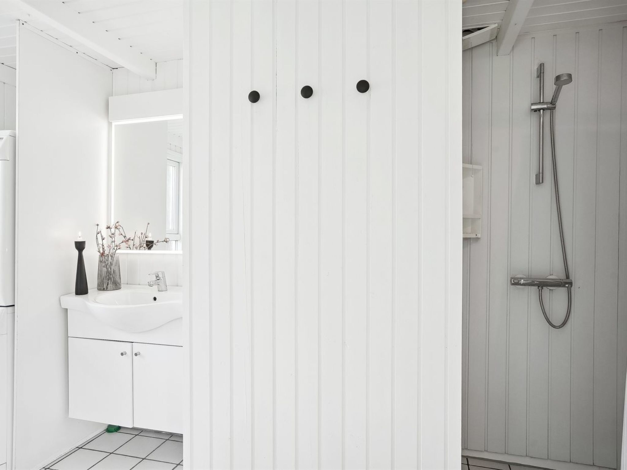Een moderne badkamer met een wit wastafelmeubel, een spiegel en een douchehoek.