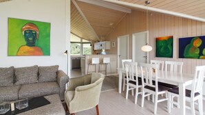 Een modern interieur met een eethoek, een bank en kunstwerken aan de muren.