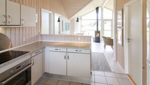 Een moderne keuken met een centraal eiland, inbouwmeubels en een fornuis.
