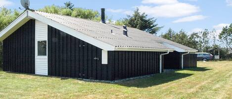 Un bâtiment d’un seul étage, doté d’un toit en pente, d’une antenne parabolique et d’une cheminée.