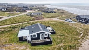 A coastal house with a large deck, surrounded by a grassy landscape and a view of the sea. - "Adina" - 50m from the sea by Interhome (Hjørring)