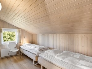 A room with a sloped ceiling, a bed, a desk, and a chair. - "Otta" - 779m from the sea by Interhome (Hjørring)