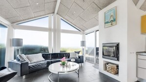A modern living room with a black leather sofa, a round coffee table, and a large TV. - "Antonie" - 95m from the sea by Interhome (Hjørring)