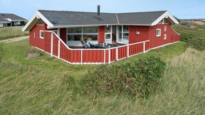 Un bâtiment rouge avec un toit plat, un balcon et une cheminée.