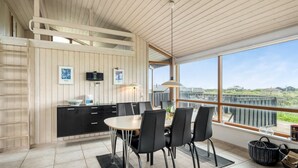 Una cocina moderna con comedor, ventanas amplias y vistas al paisaje.