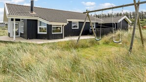 Une maison moderne dotée d’un grand porche et d’une balançoire.
