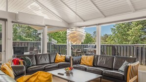 Ein moderner Außenbereich mit Ecksofa, Couchtisch und einer auffälligen geometrischen Leuchte.
