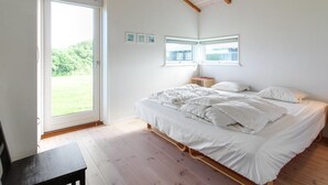 Ein Schlafzimmer mit Bett, Schreibtisch und Fenster.
