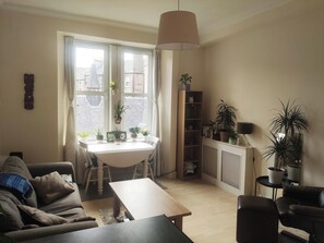 Relax in this inviting living room with a dining table, comfortable sofa, and a cozy atmosphere.