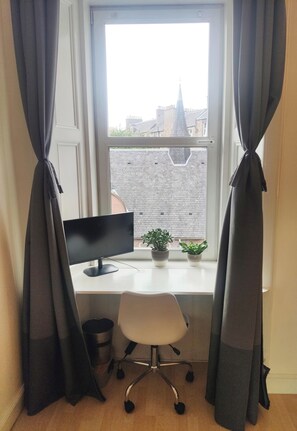 Work in comfort with a desk by the window, a computer monitor, and a comfortable office chair.