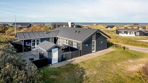 Et moderne hus med stor terrasse og havudsigt.